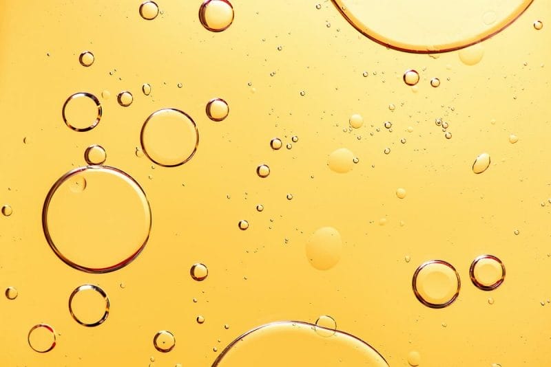 Abstract image of bubbles in a yellow liquid.